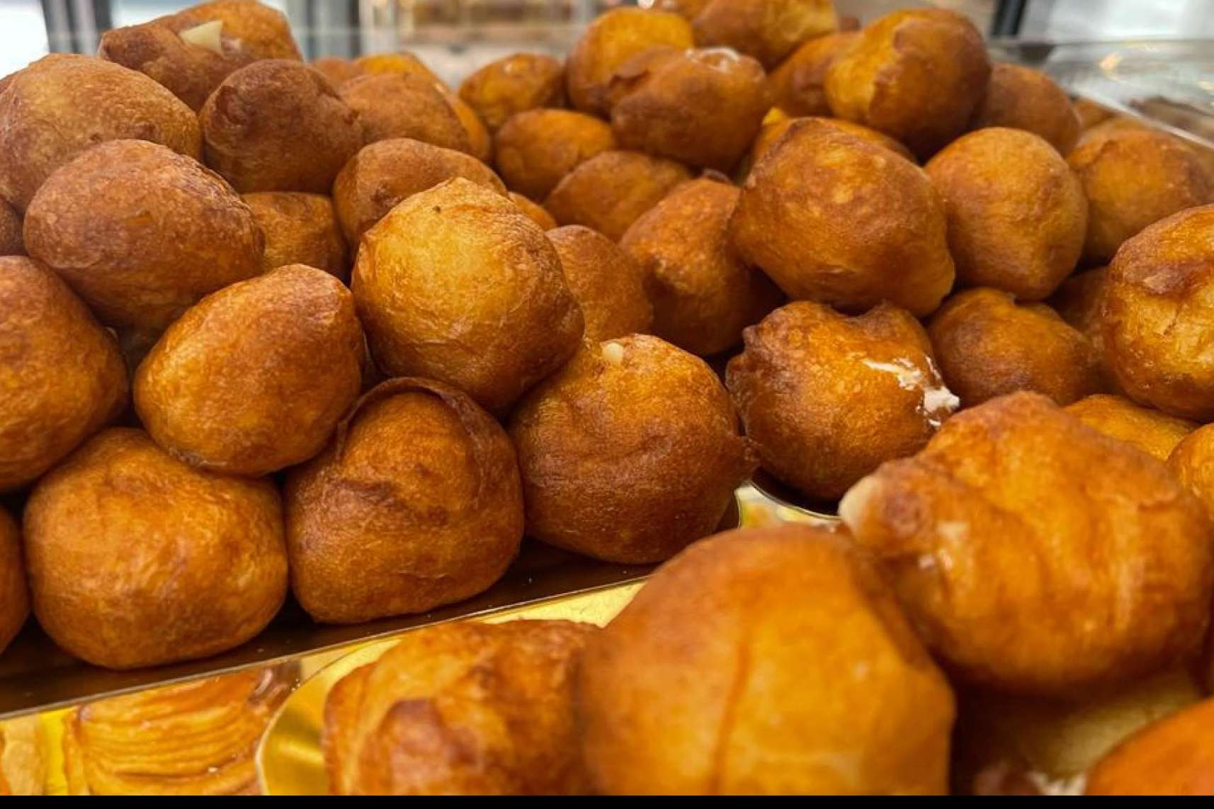 Dulces tradicionales como buñuelos y huesos de santo disponibles en El Panazo
