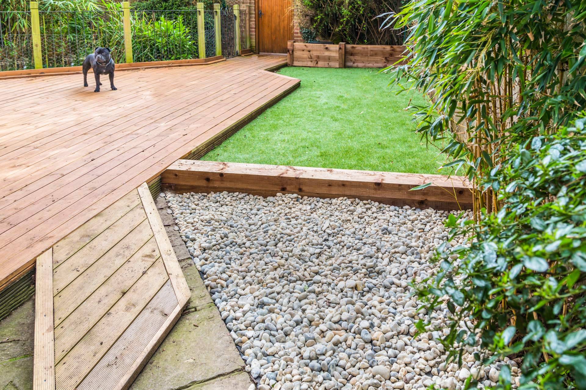 Diseño de terrazas con jardines con piedras blancas y césped artificial